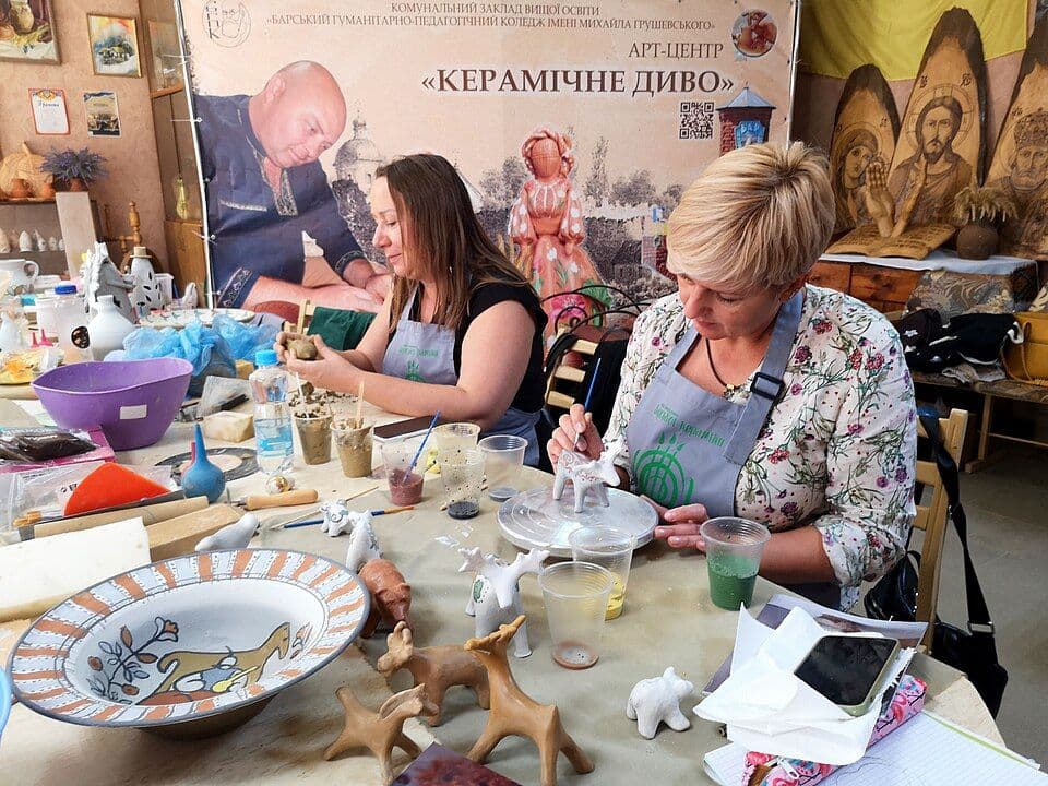 Учасниці майстер-класу розписують кераміку за спільним столом