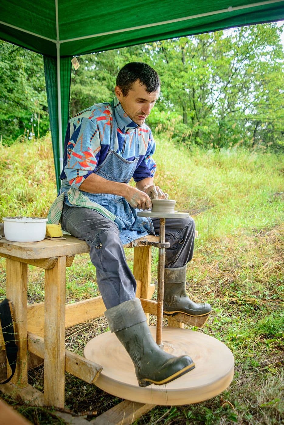 Гончар працює на ножному колі просто неба